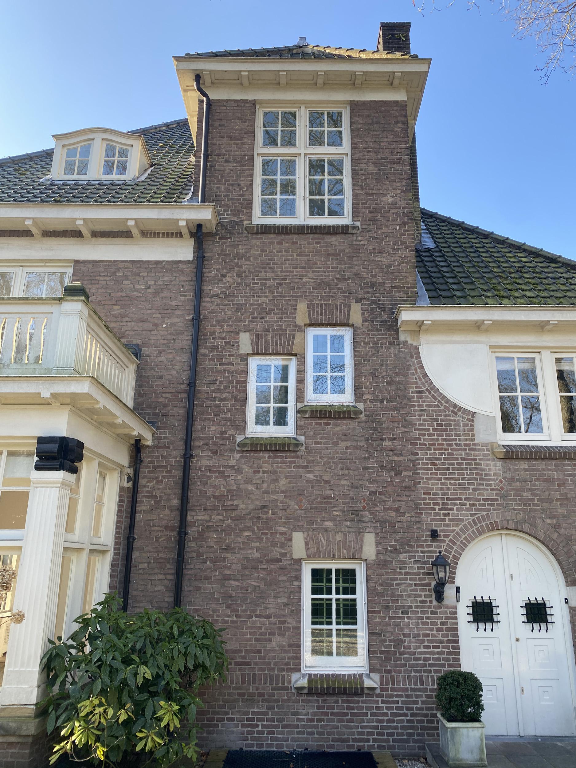 Detail van de voorgevel van de villa aan de Schouwweg in Wassenaar met ramen van het trappenhuis en de voordeur